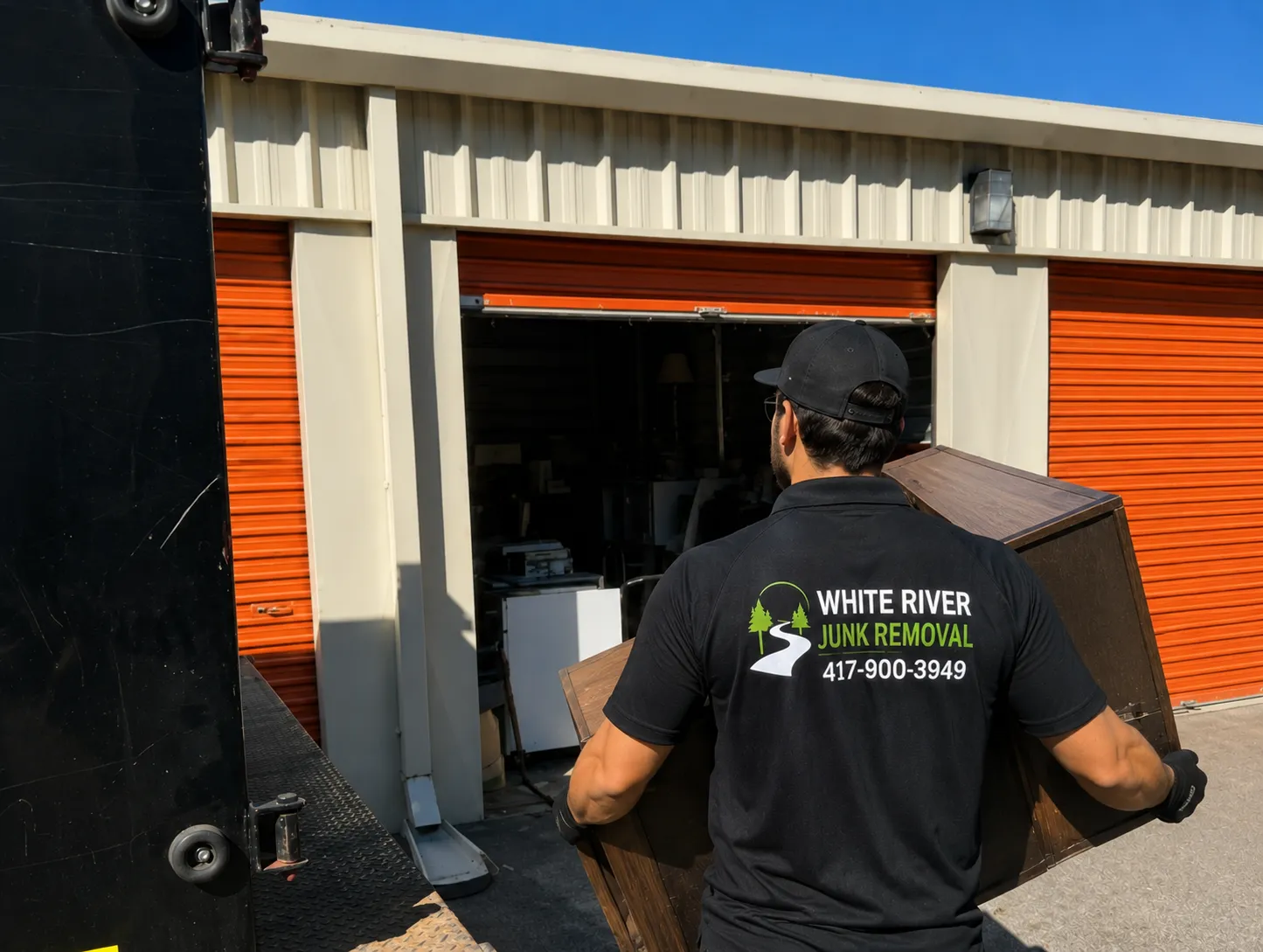 A crew member carrying furniture out of a self-storage unit